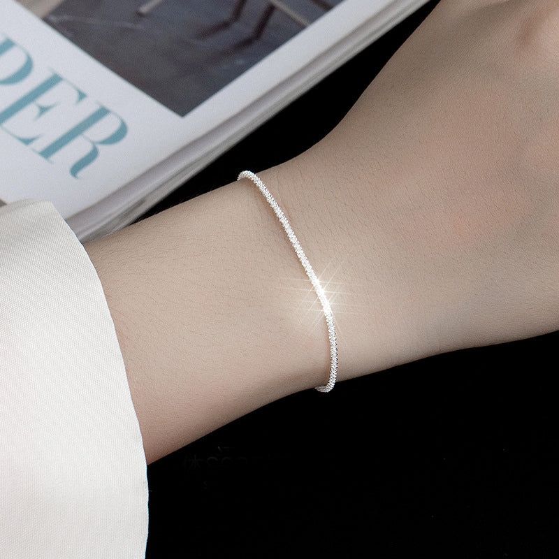 Un modelo usando el Brazalete de Cadena de Gypsophila Brillante de Plata de Ley 925, mostrando su delicado diseño en la muñeca.