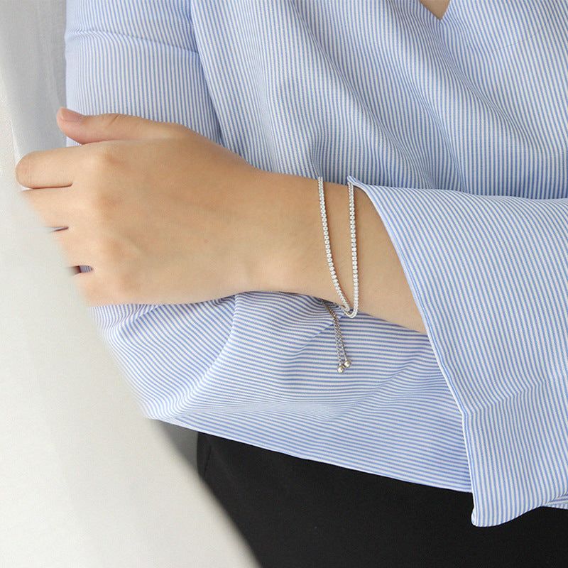 Eine Produktpräsentation des Großhandels 925er Sterlingsilber doppellagigen CZ-Tennisarmbands, das sein minimalistisches Design und die funkelnden Zirkonia-Steine hervorhebt.