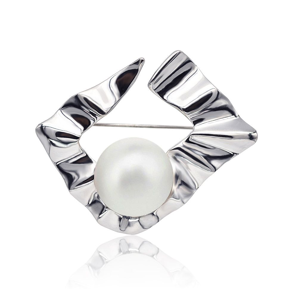 صورة مقربة ل brooch اللؤلؤ الصناعي المصقول، تبرز تصميمه المميز المموج والمجعد من المعدن بلون الفضة المحيطة بلؤلؤة بيضاء مركزية.