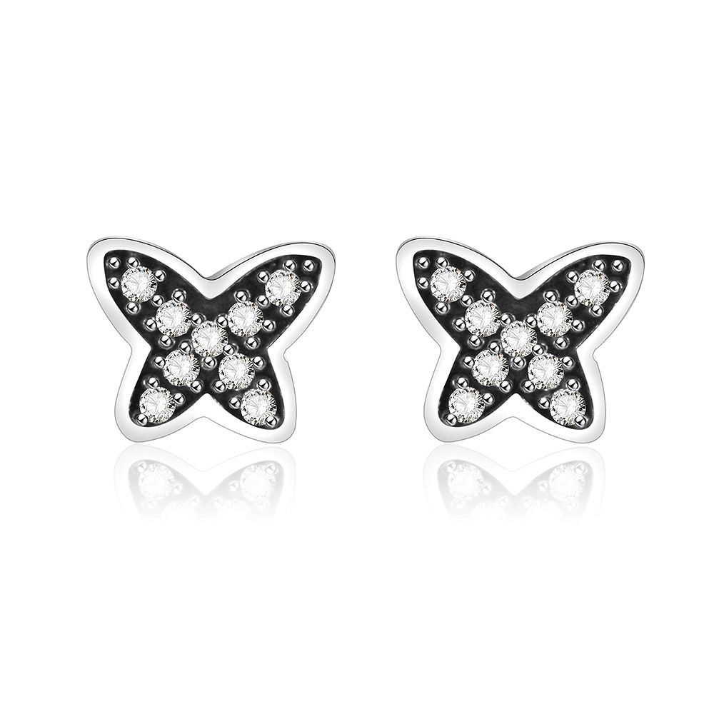 Un gros plan détaillé des petites boucles d'oreilles en argent avec zirconia en forme de papillon, mettant en avant le design complexe du papillon et les pierres précieuses transparentes scintillantes sur une base en argent sterling 925.