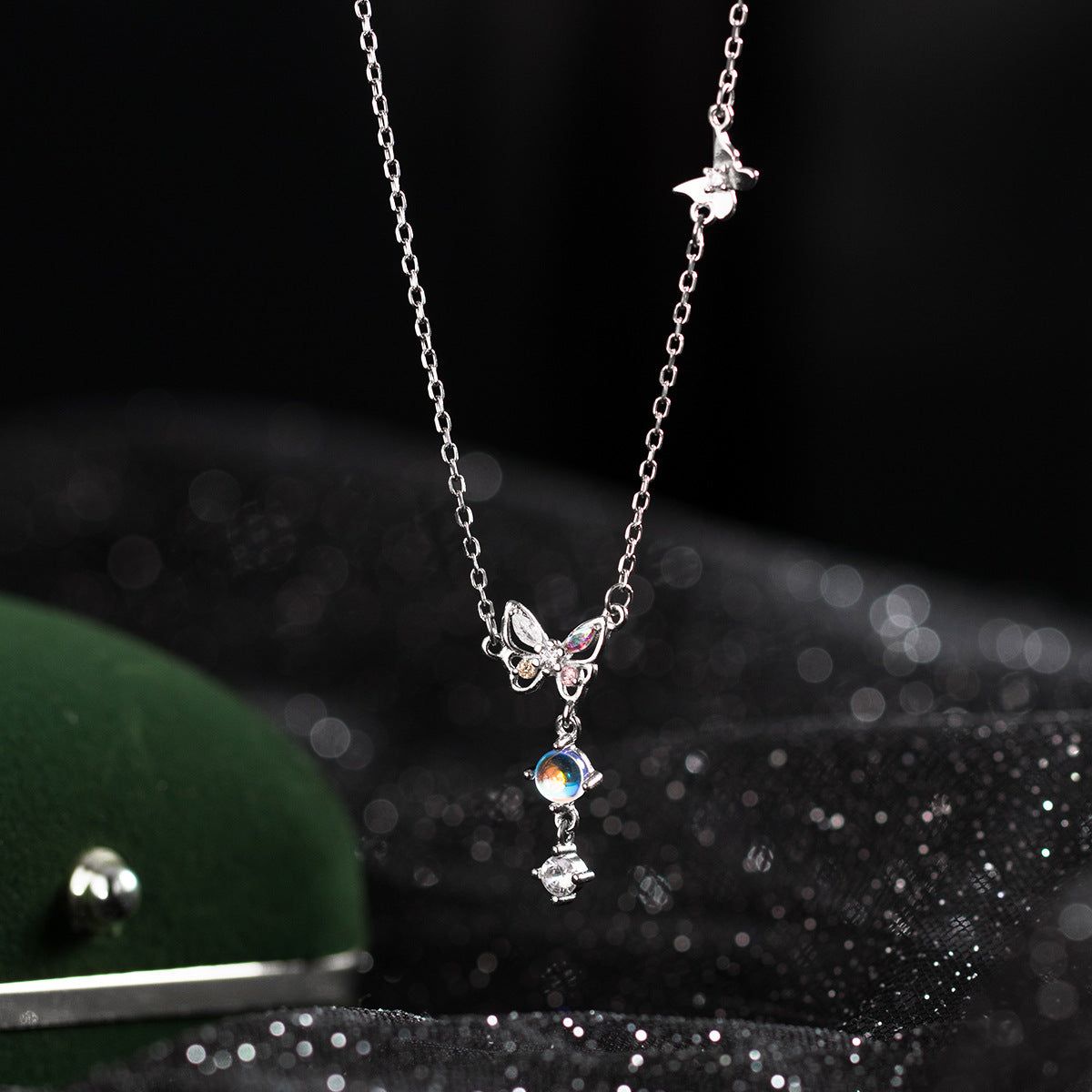 Close-up of a 925 sterling silver butterfly necklace from the set, showcasing the intricate details of the pendant with sparkling iridescent zircon stones.