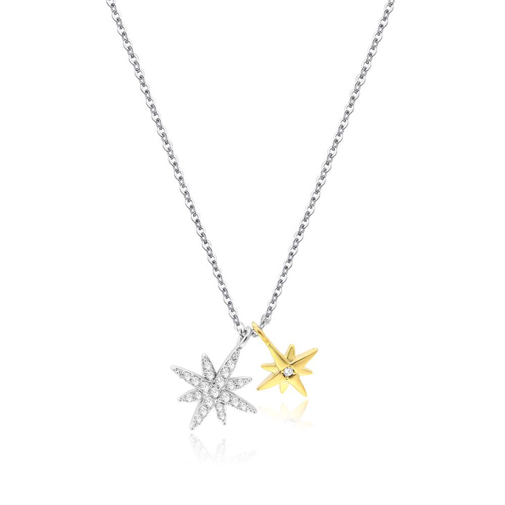 Um close do Colar Double Dangle Starburst, mostrando seu design bicolor com uma estrela de zircônia cúbica prateada e um pingente de estrela dourada polida.