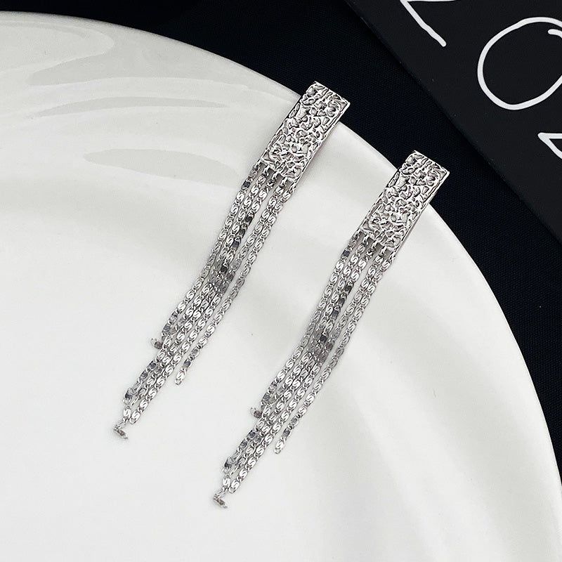 Un paio di orecchini a frangia lunga in argento sterling 925 con un ciondolo rettangolare e un design di catena delicato, esposti su uno sfondo bianco pulito.