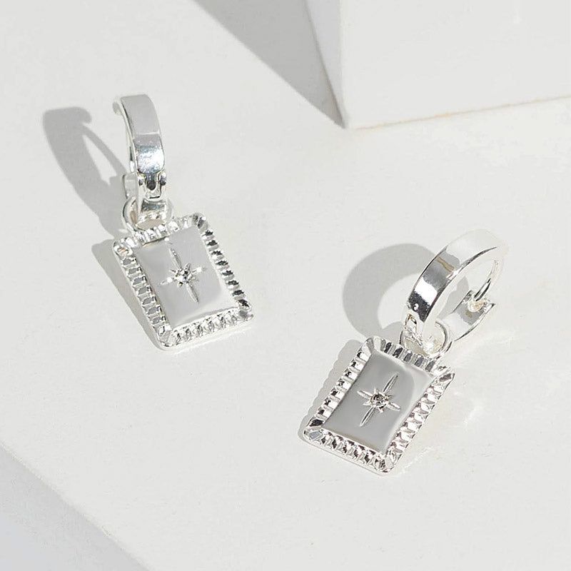 A pair of 925 sterling silver celestial square charm dangle earrings with a detailed starburst pattern, shown on a white background.
