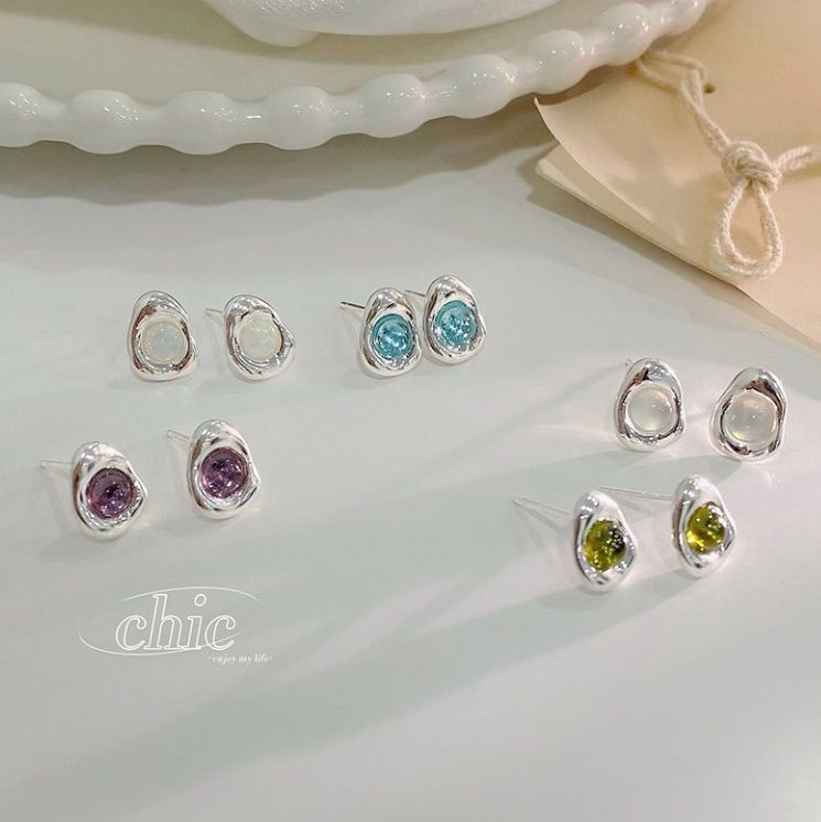Una collezione di orecchini a perno in argento sterling 925 con vivaci e colorate pietre di zirconia cubica in vari tagli e montature.