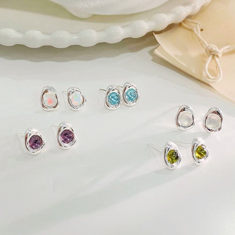 Una collezione di cinque paia di orecchini a bottone in argento sterling 925, ciascuno con una pietra di opale colorata e di forma unica in varie tonalità vivaci.