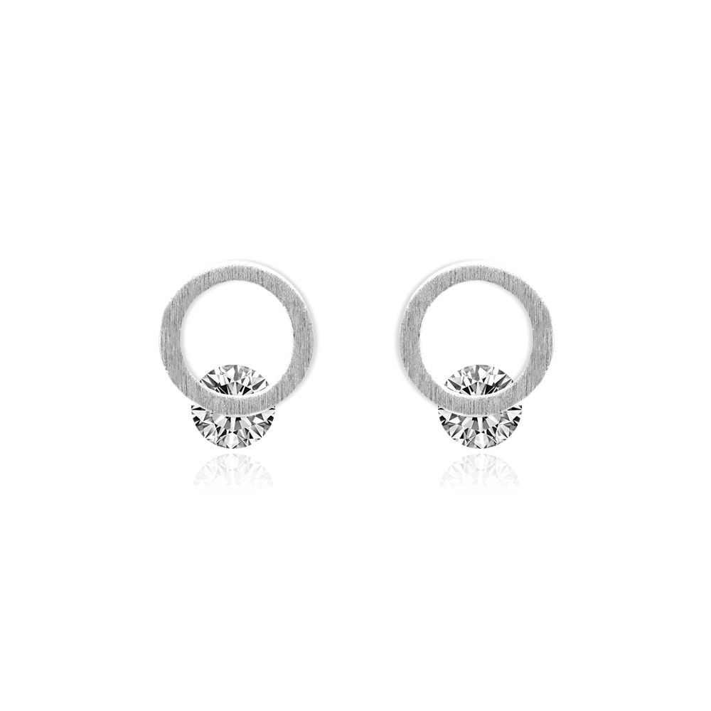 Primo piano di orecchini in argento placcato a forma di cerchio con CZ, che mostrano la pietra centrale in zirconia cubica scintillante su un perno in ottone placcato argento.