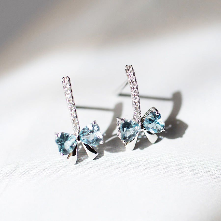 Ett par nätta 925 sterling silver knutstudsörhängen, var och en med en central ljusblå kubisk zirkonia och accentuerad med klara kristaller.