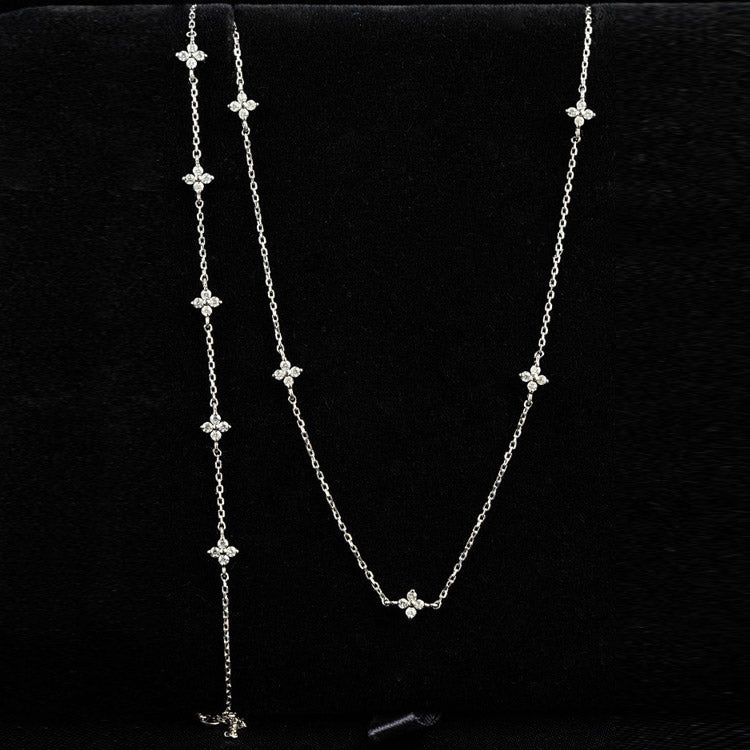 A model wearing a delicate 925 sterling silver necklace featuring a sparkling zircon 4-leaf flower charm.