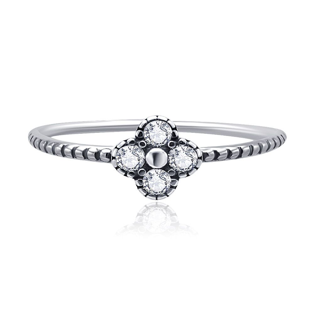 Close-up van de kleine bloemenring met vier bloemblaadjes van 925 sterling zilver, met de ingewikkelde bloemvormige zirkonia-zetting.