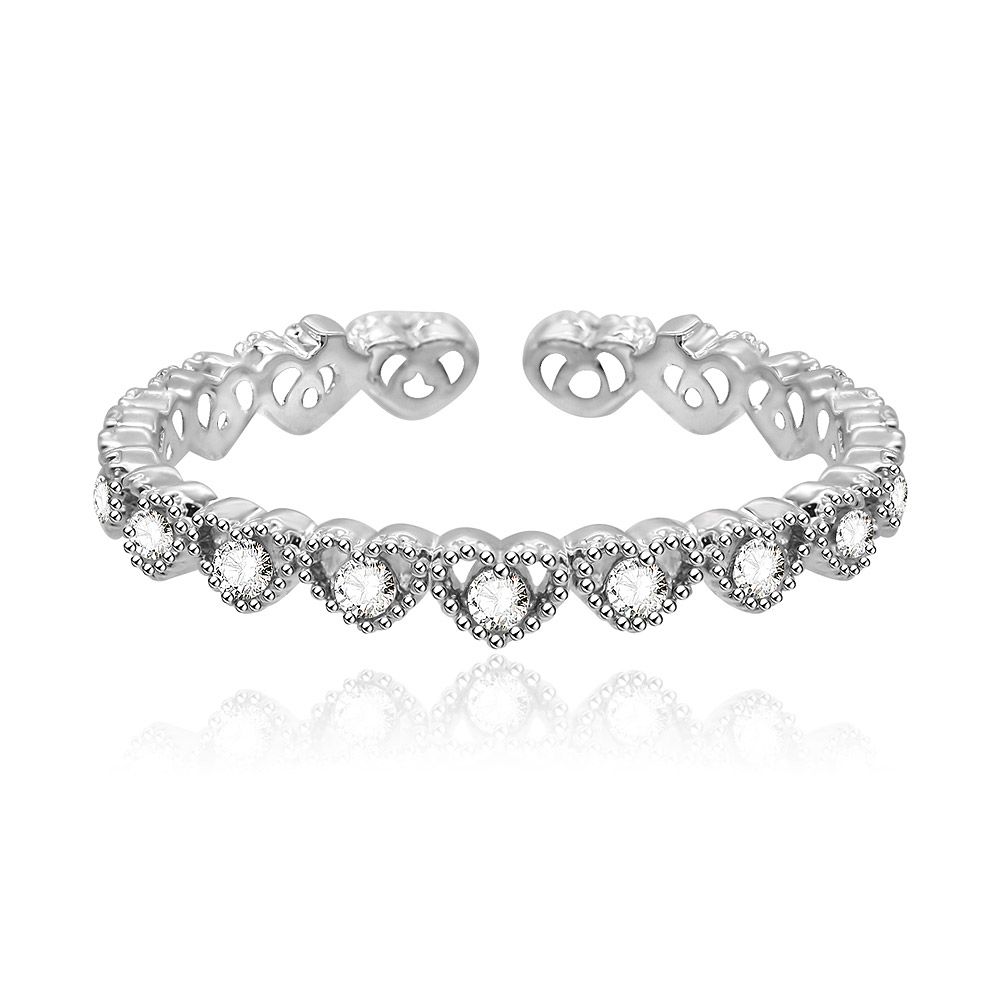 Primo piano di un anello a fascia a forma di cuore ispirato al vintage, realizzato in ottone placcato rodio e adornato con pietre di zirconia cubica bianche.