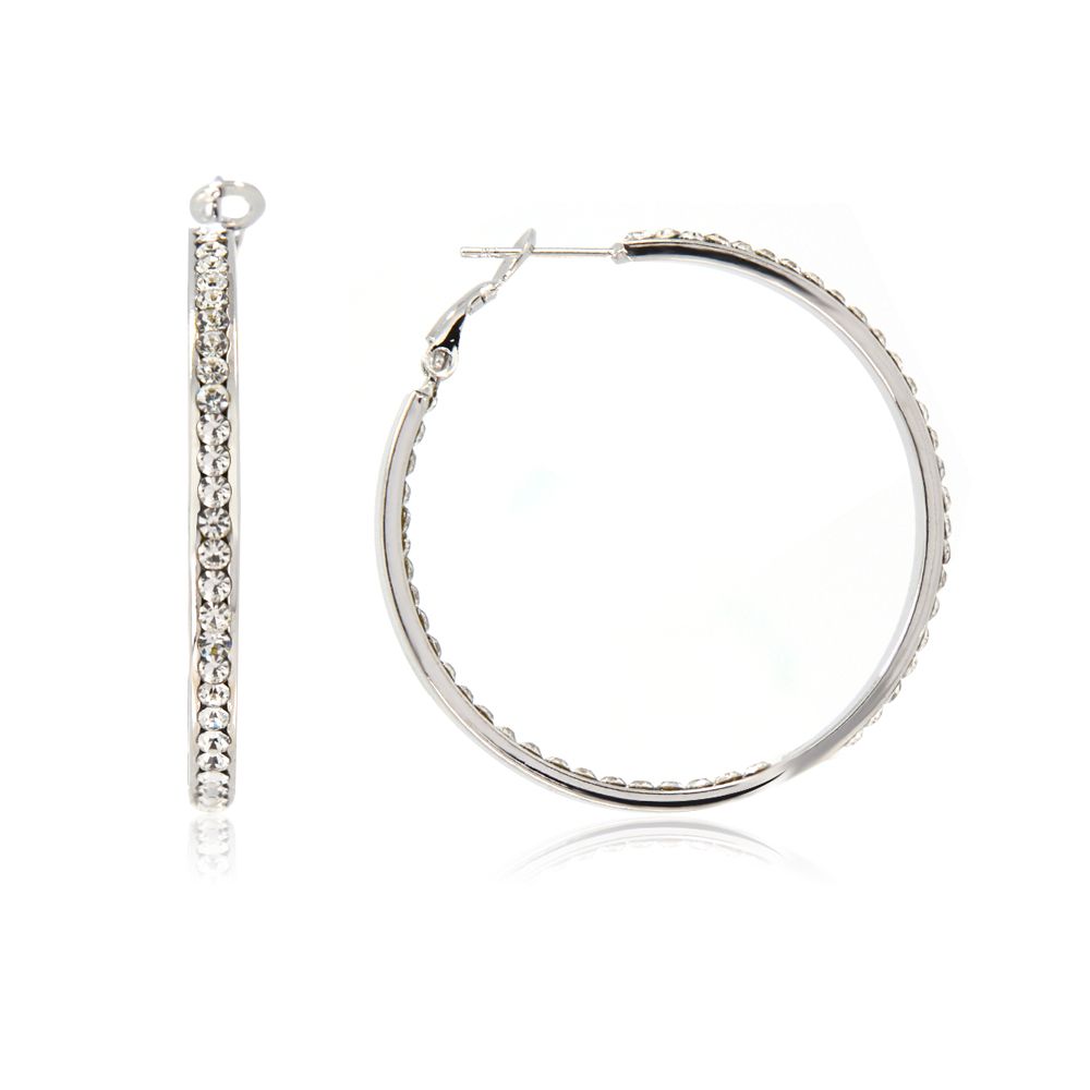 Un gros plan des boucles d'oreilles créoles rondes en cristal de rhodium, montrant les détails des fixations en cristal tchèque blanc sur la créole de ton argent.