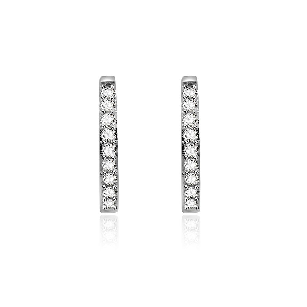 Una vista en primer plano de los pendientes Huggie Eternity Circle Clear CZ, que muestran los aros de latón chapados en rodio adornados con piedras de circonio cúbico brillantes.