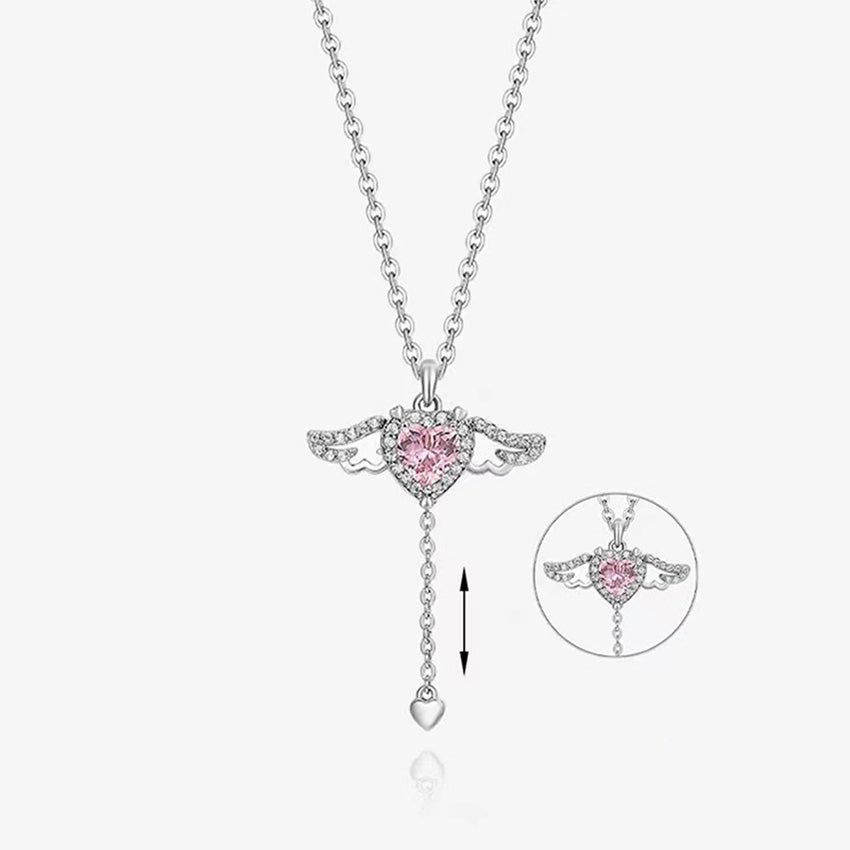 Een close-up van de 925 sterling zilveren ketting met een delicate engelenvleugelhanger die een schitterende roze hartvormige edelsteen omarmt.