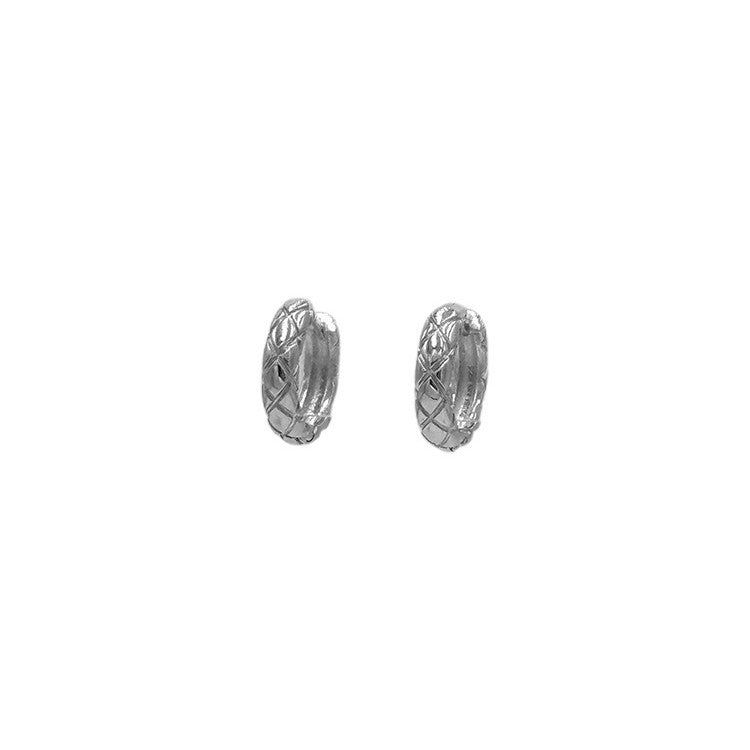 Una vista ravvicinata degli orecchini a cerchio trapuntati classici in argento sterling 925, che mostrano il loro intricato motivo testurizzato e la finitura placcata in platino.