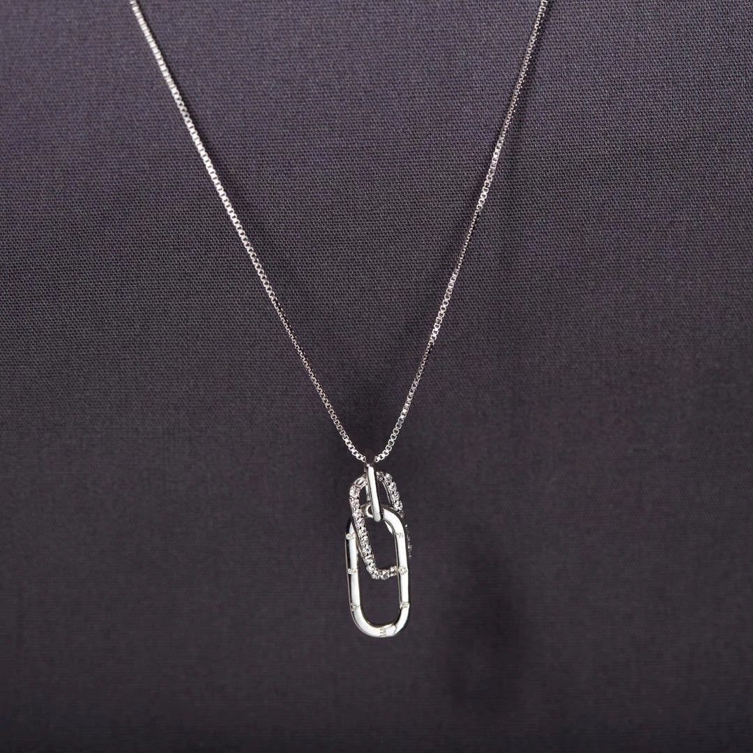 A close-up of the 925 sterling silver necklace featuring an interlocking oval pendant, with one link encrusted with sparkling zircon stones.