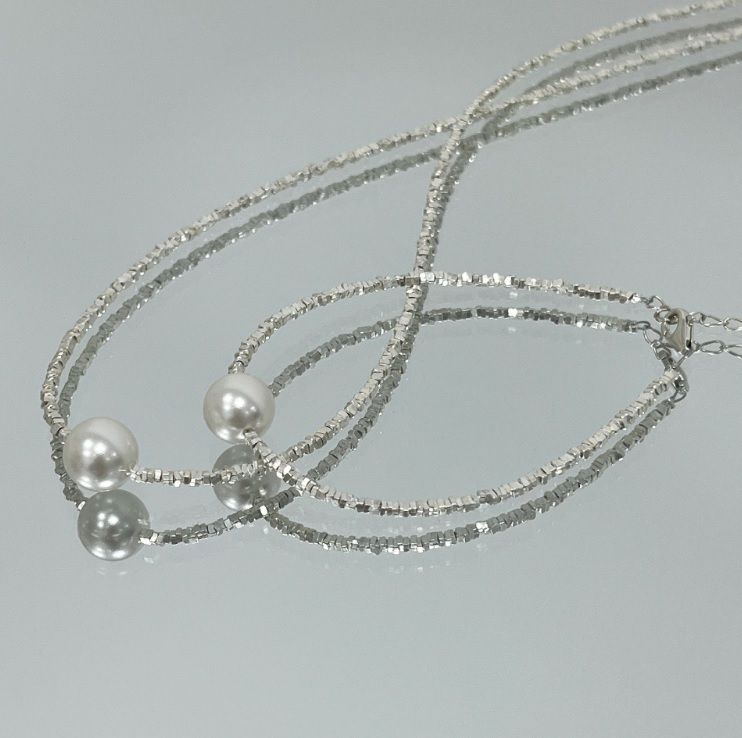 Detailed view of the 925 Sterling Silver Faceted Beaded Pearl Necklace, showcasing its multi-strand design with silver beads and prominent freshwater pearls.