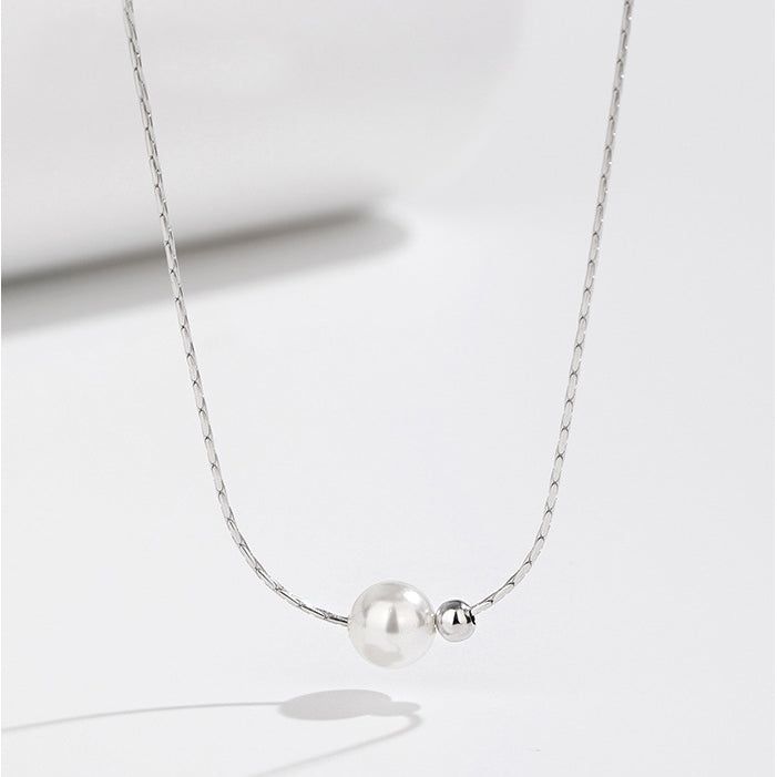Elegante collar de cadena de hueso de serpiente de plata esterlina 925 con una perla blanca lustrosa y una delicada cuenta de plata, sobre un fondo blanco limpio.