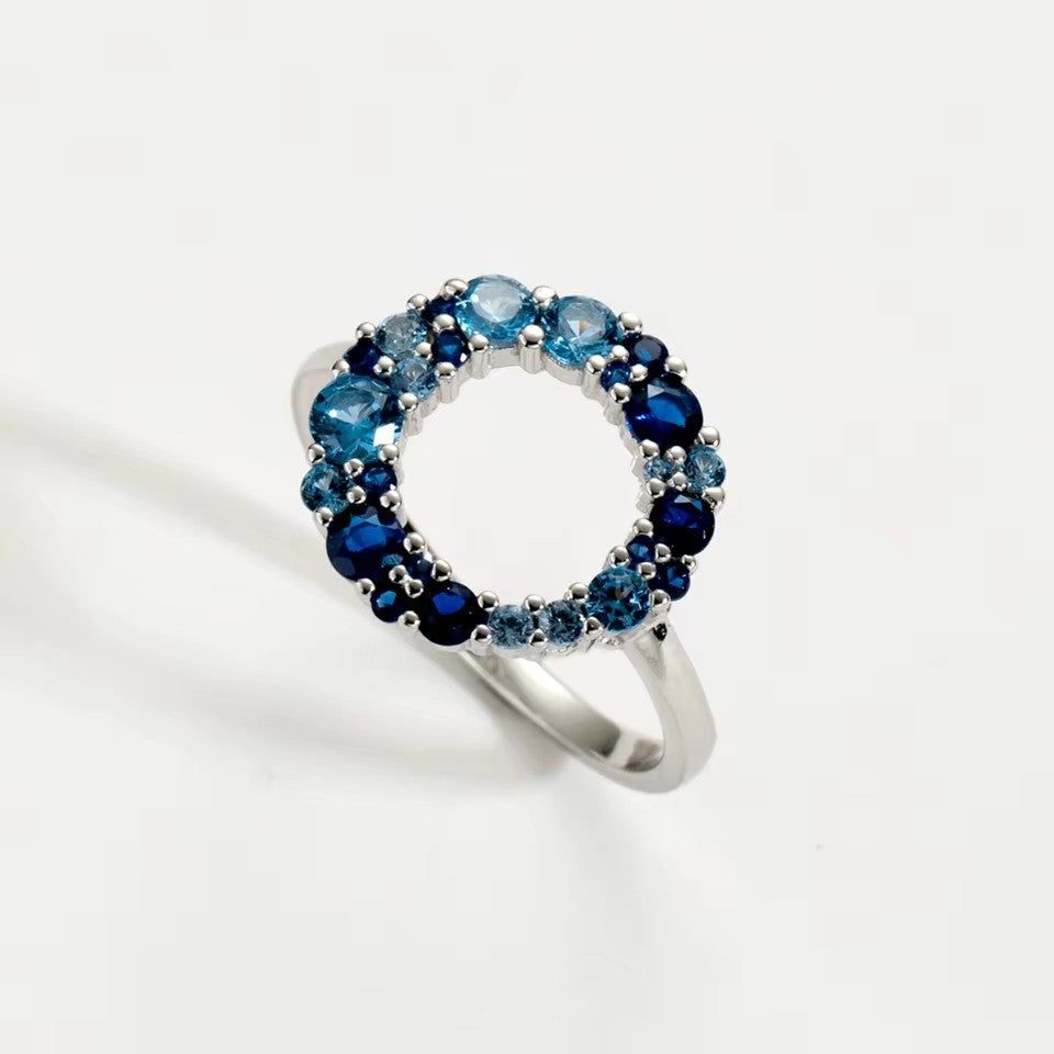 Ein moderner Verlobungsring aus 925er Sterlingsilber aus einem Set von fünf, mit einem brillanten runden blauen Zirkonia-Stein auf einem polierten Band.