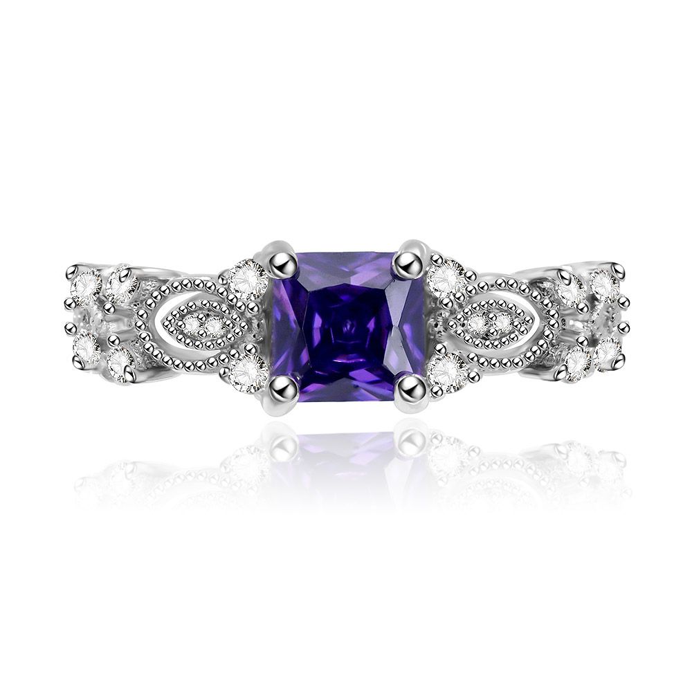 Vista frontale dell'anello quadrato in ametista viola, che mette in mostra la pietra preziosa quadrata centrale di colore viola circondata da accenti scintillanti di zirconia cubica su una fascia in ottone placcata in rodio.
