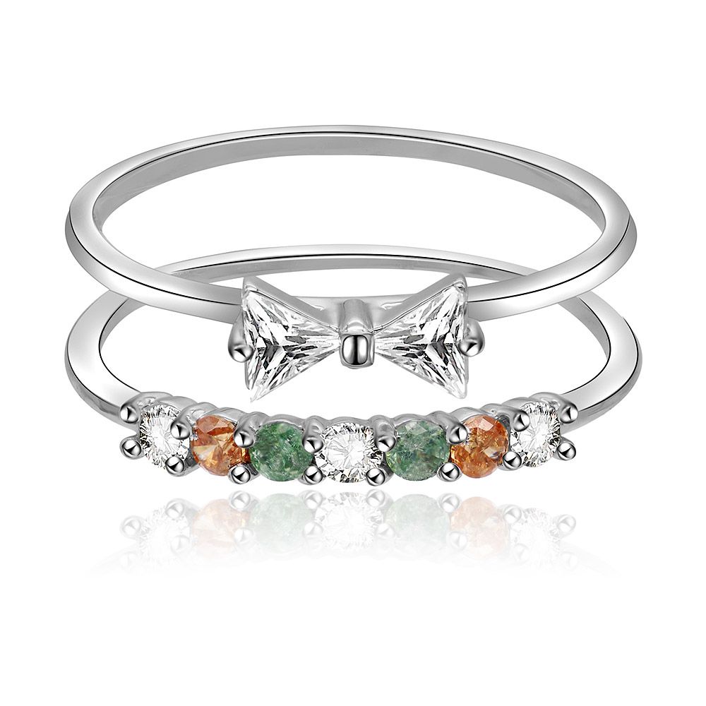 Una coppia di anelli a fascia multicolore impilabili in due pezzi realizzati in ottone placcato rodio, adornati con scintillanti pietre di zirconia cubica bianche, rosa, champagne e verde chiaro.