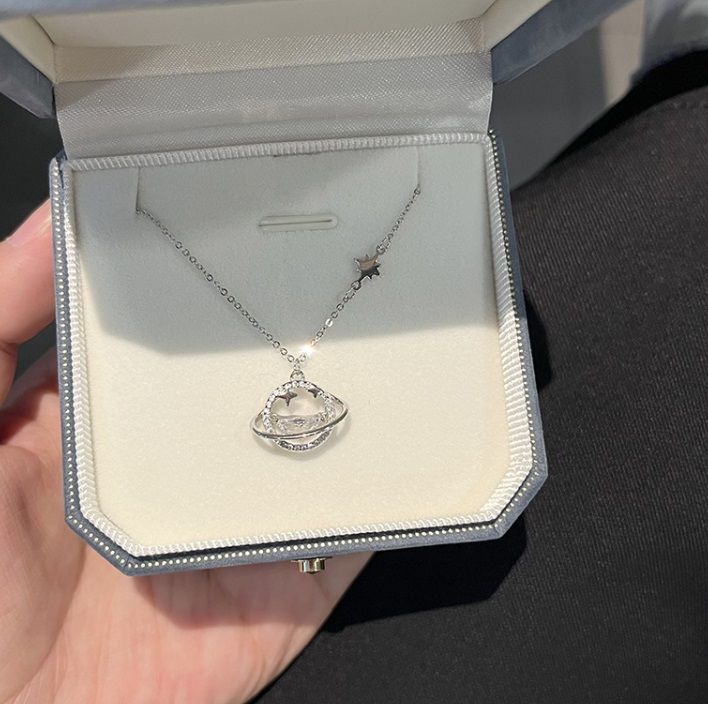 925 Sterling Silver Star Moon Space Necklace with a Saturn-shaped pendant, elegantly displayed in a jewelry box.