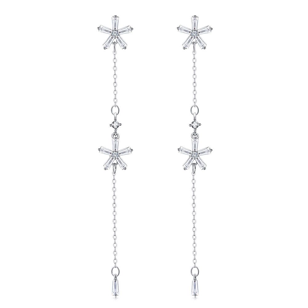 Un par de pendientes colgantes de diamantes en corte baguette con forma de flor, que exhiben un diseño de múltiples componentes con partes superiores en forma de estrella y cristales colgantes sobre un fondo blanco.