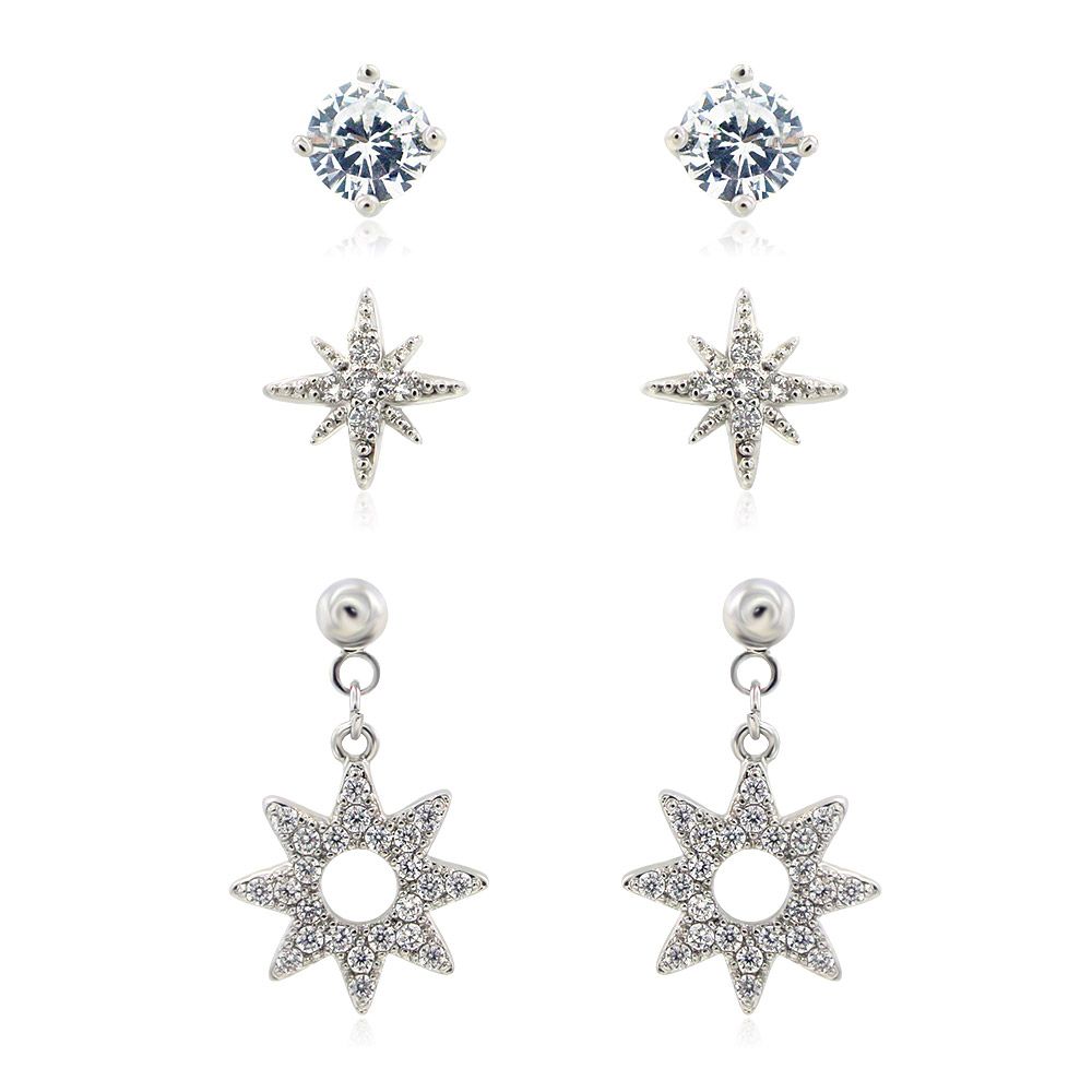 Un conjunto de tres delicados pendientes de poste chapados en rodio, que incluye un solo arete de CZ, un arete en forma de estrella y un diseño de estrella colgante con circonitas.