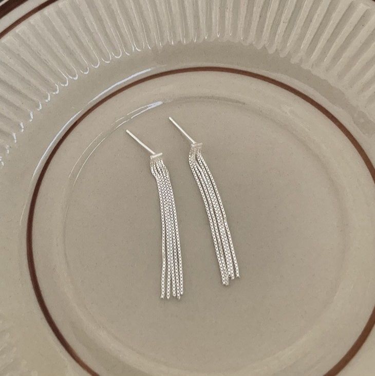 Un paio di eleganti orecchini a frangia lunghi in argento sterling 925 con una finitura lucida, che mettono in mostra il design intricato della frangia.