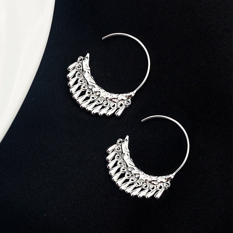 Un paio di orecchini a forma di C in argento sterling 925 con texture martellata e frange corte, esposti su uno sfondo bianco.