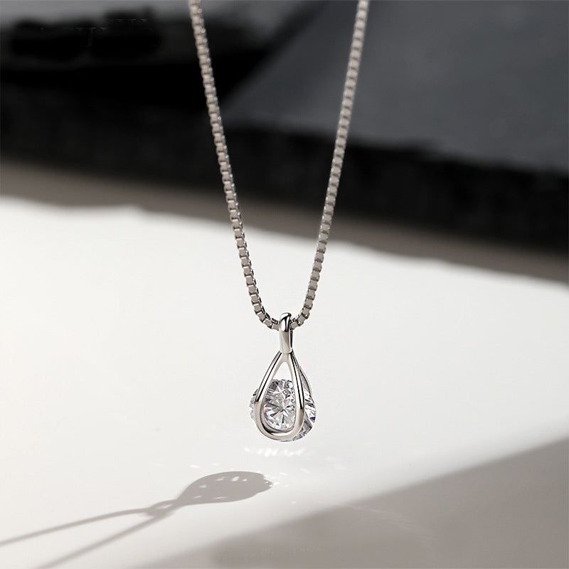 En högkvalitativ studiofotografi av ett 925 sterling silverhalsband med ett elegant tårformat hängsmycke med en enda, briljant kubisk zirkonia.