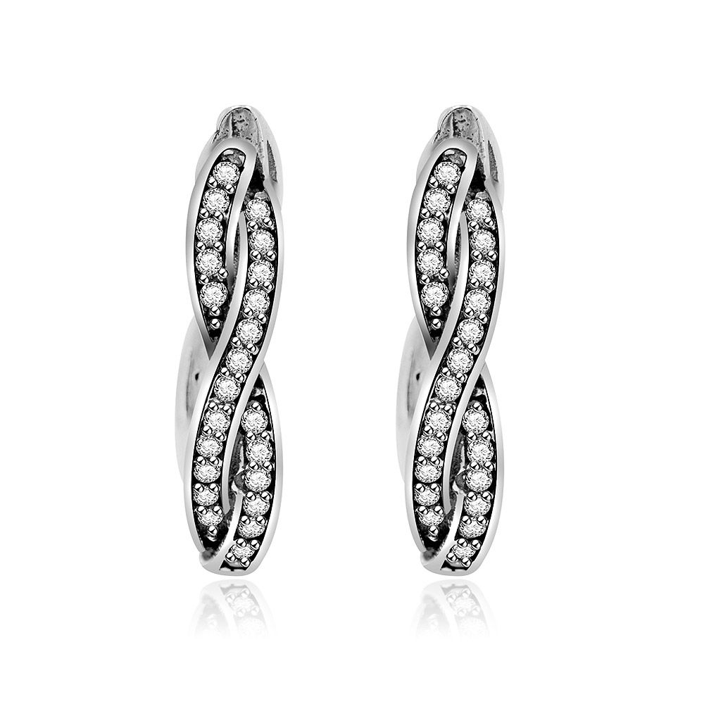 Scatto ravvicinato in studio di orecchini huggie a cerchio in argento sterling 925. Gli orecchini presentano un design unico attorcigliato con due canali finemente impostati con brillanti e scintillanti pietre in zirconia cubica.
