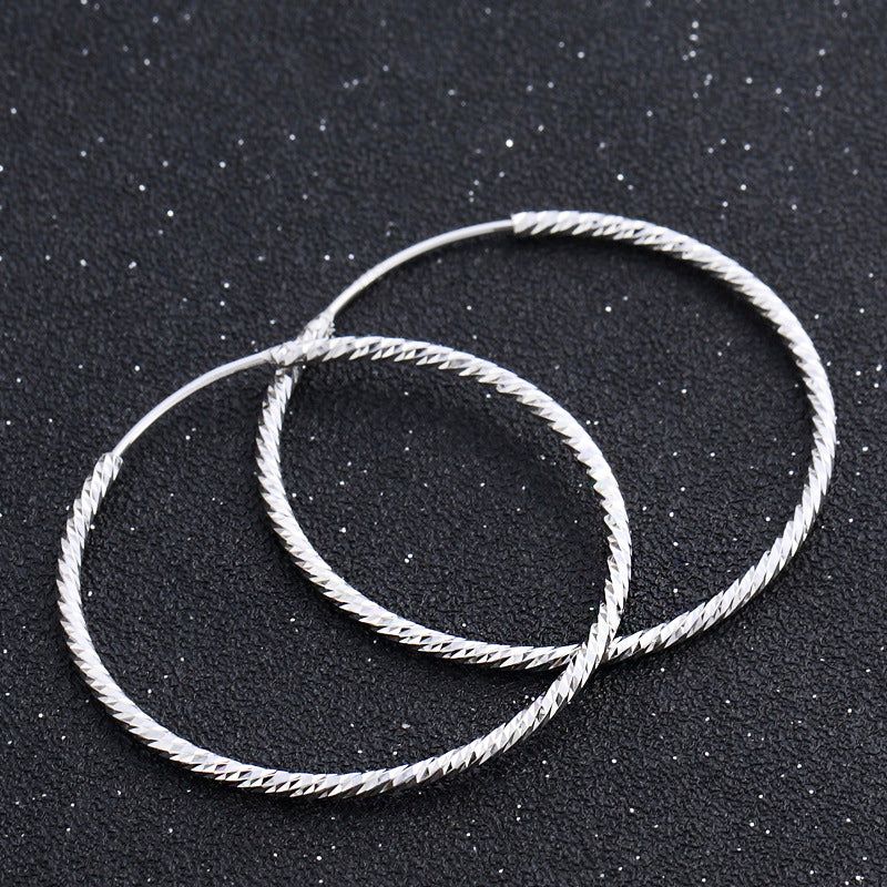 Un paio di orecchini a cerchio grandi in argento sterling 925 testurizzati, con un diametro di 37 mm, che mostrano un design a loop classico.