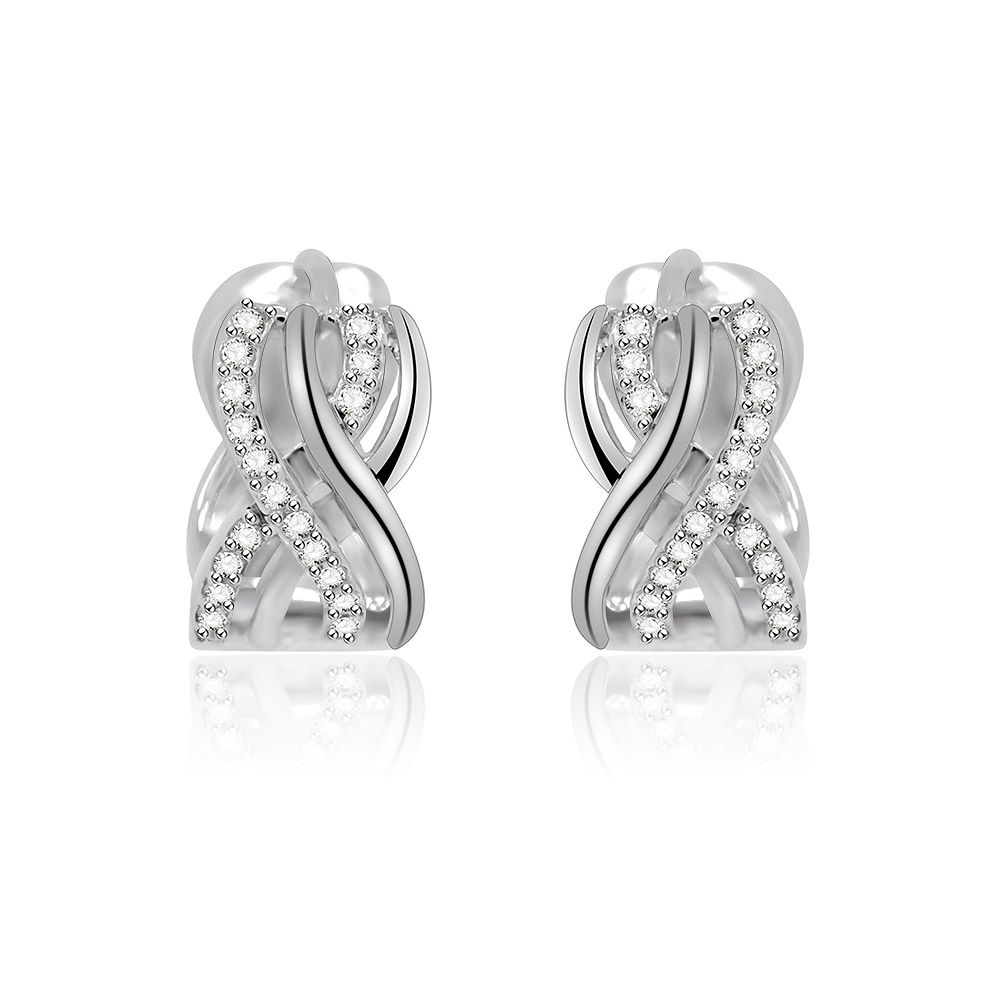 Gros plan sur les boucles d'oreilles Huggie Inter Cross Clear CZ, mettant en avant leur design torsadé complexe en laiton plaqué rhodium, orné de pierres en zircon cubique blanches étincelantes.