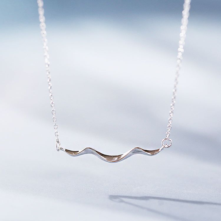 Un primer plano del Collar de Ola de Costa Simple de Plata Esterlina 925, mostrando el diseño de colgante ondulado detallado y elegante.