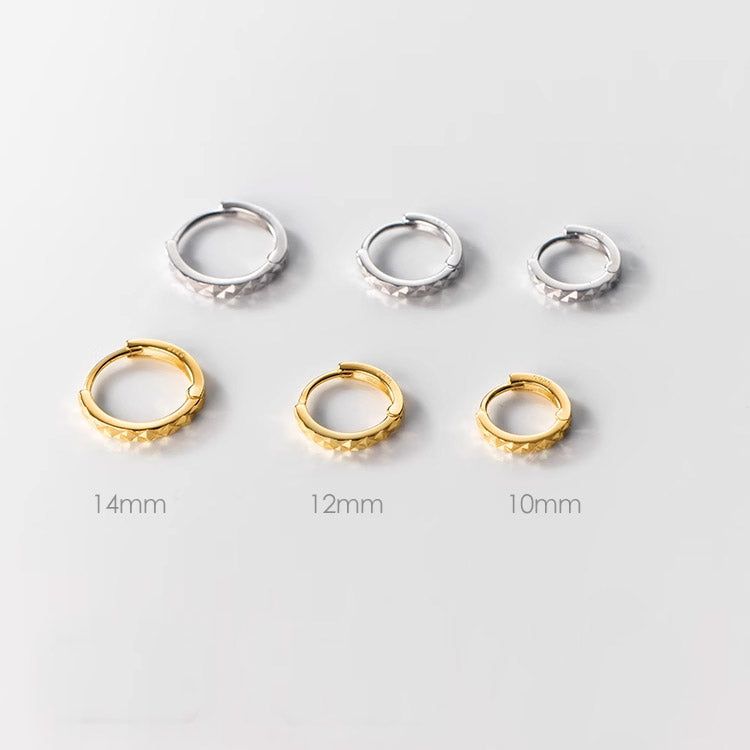 Uma coleção de brincos huggie minimalistas de prata esterlina 925 disponíveis em acabamentos prateados e dourados, com tamanhos de 10mm, 12mm e 14mm exibidos.