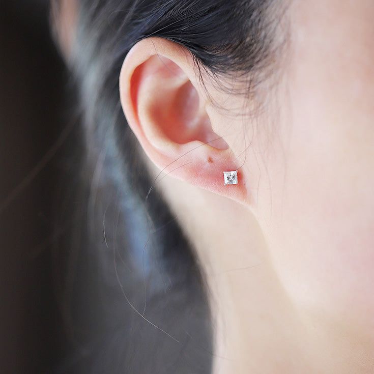 En närbild av ett enda 925 sterling silver mini fyrkantigt studörhänge med en glittrande cubic zirconia-sten.