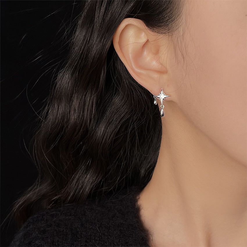 Una modelo mostrando el elegante pendiente Star Drop, destacando su diseño celestial con piedras de zirconia CZ y cómo cuelga con gracia.