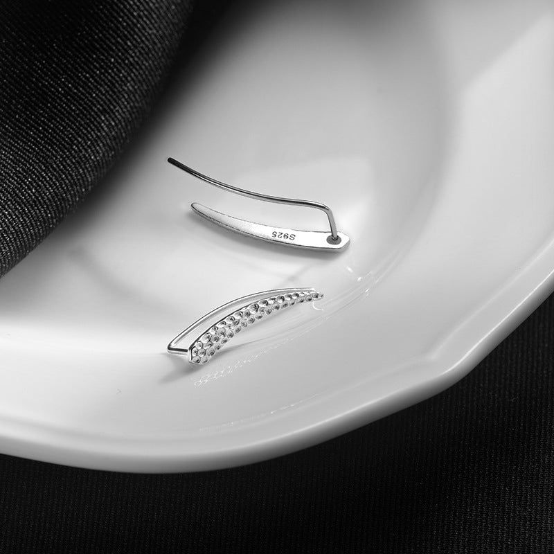 Un paio di orecchini cuff climber in argento sterling 925 di un set di cinque paia, che mostrano una dettagliata texture concava-convessa e il marchio S925.