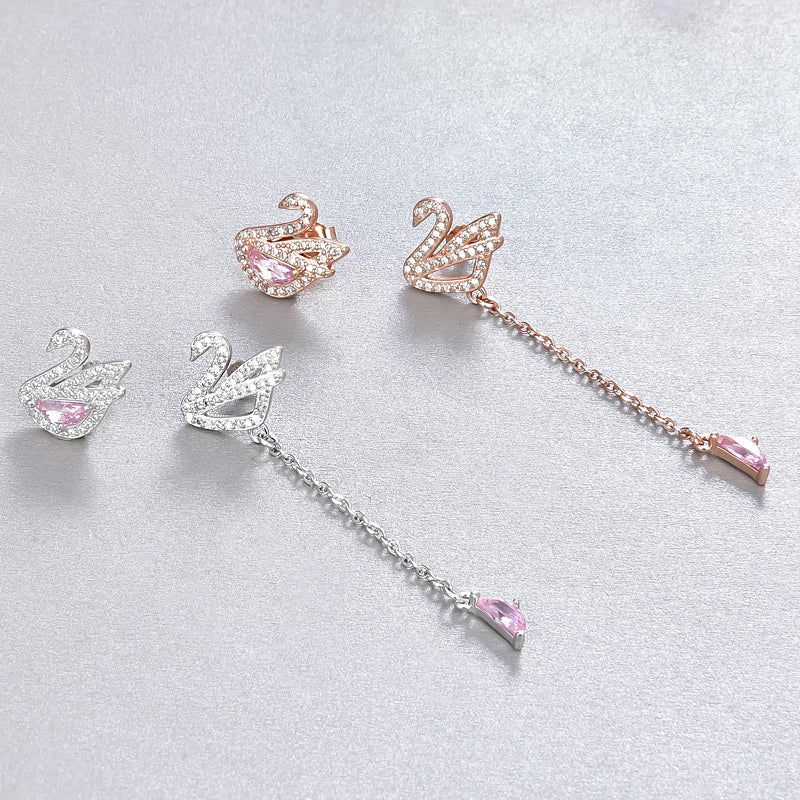 A pair of 925 sterling silver asymmetrical crystal swan drop stud earrings shown in both silver and rose gold finishes.