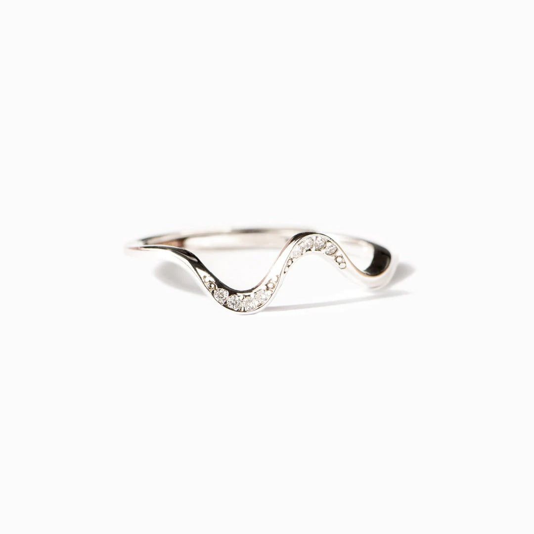 Un anillo Rhythmic Dance de plata esterlina 925 con una distintiva forma de S ondulada, adornado con cristales de circonio brillantes, sobre un fondo blanco limpio.