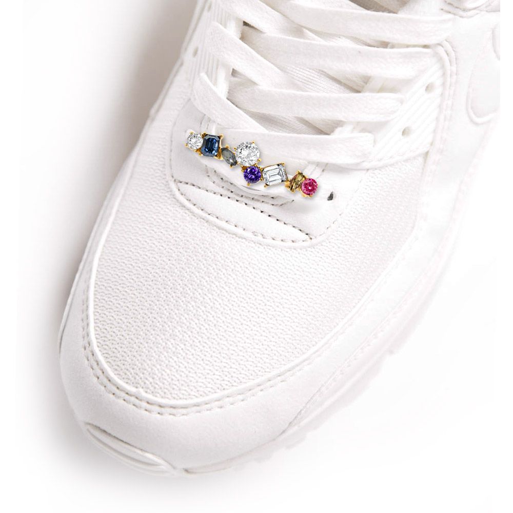 A vibrant Colorful Glass Shoe Charm with multi-colored crystals and gold plating, elegantly displayed on the laces of a white sneaker.