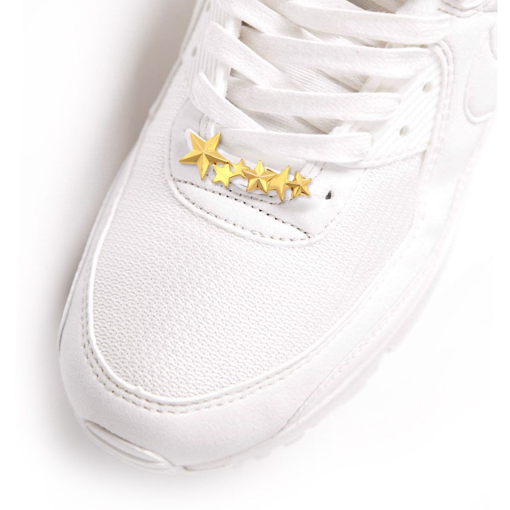 Una sneaker bianca elegante con i fermalacci dorati Six Stars, che dimostra come questi ciondoli migliorino la moda delle calzature.