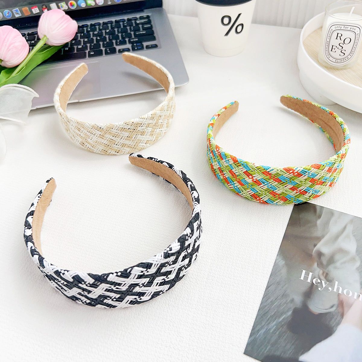 Un conjunto de tres diademas trenzadas de rafia tejida a mano en multicolor, blanco y negro, y beige, exhibidas para venta al por mayor por JR Fashion Accessories.