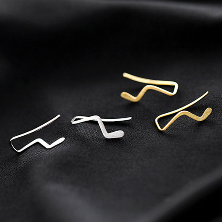 A collection of 925 sterling silver simple wave stud earrings in both silver and gold finishes, displayed on a dark surface.