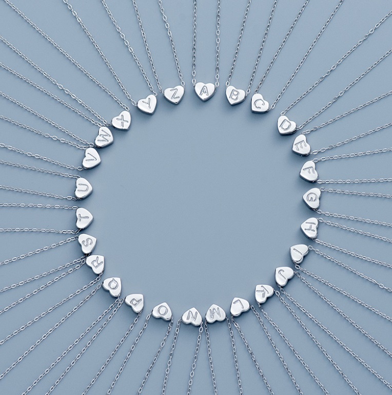 A complete set of 26 alphabet initial pendants in 925 sterling silver, shaped like hearts, showcasing the customizable options for the Heart Letter Necklace by JR Fashion Accessories.