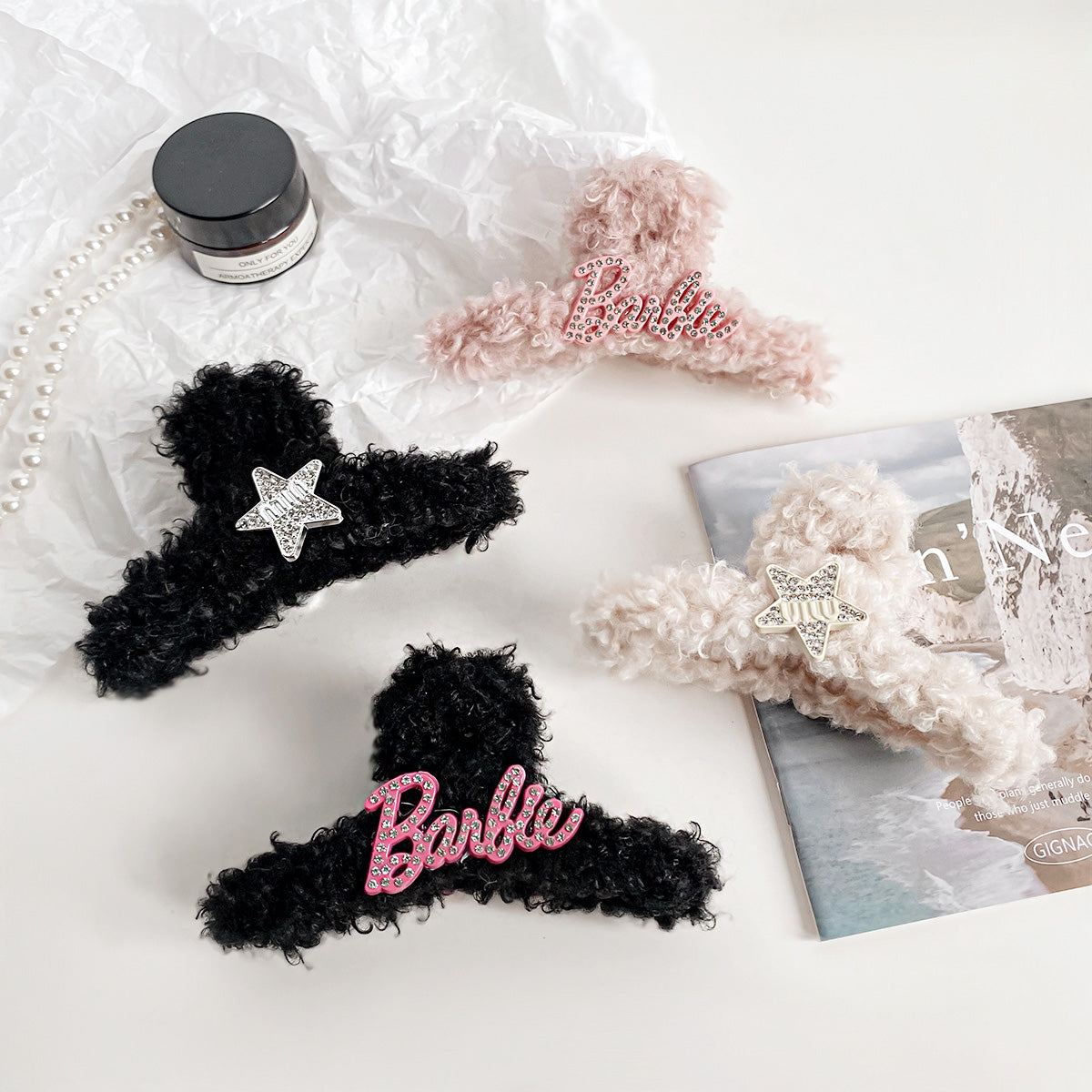 A collection of wholesale cute plush claw hair clips in various styles, including Barbie-themed, star-shaped, and rhinestone-decorated designs, displayed on a pink background.