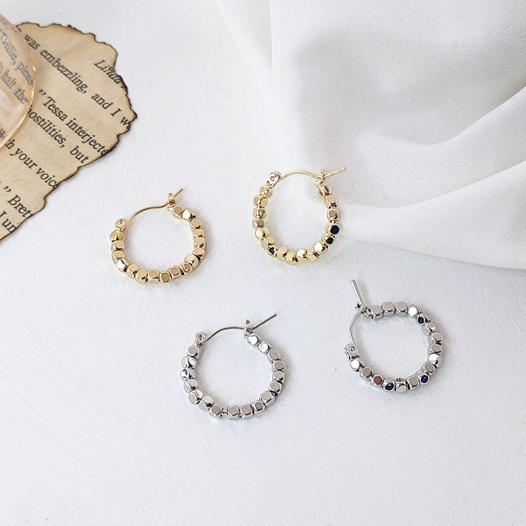 A product shot of Crushed Stone Small Square Beads Hoop Earrings, showcasing four pairs in both gold and silver finishes.