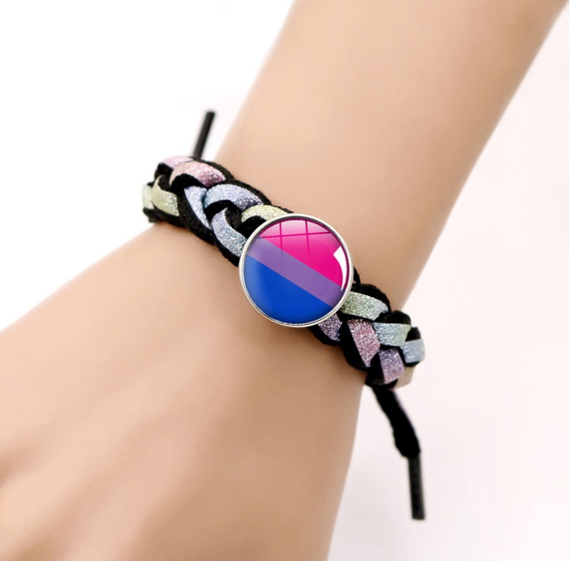 A person wearing the Handwoven Colorful Love Is Love Stretch Bracelet, which features the colors of the bisexual pride flag.