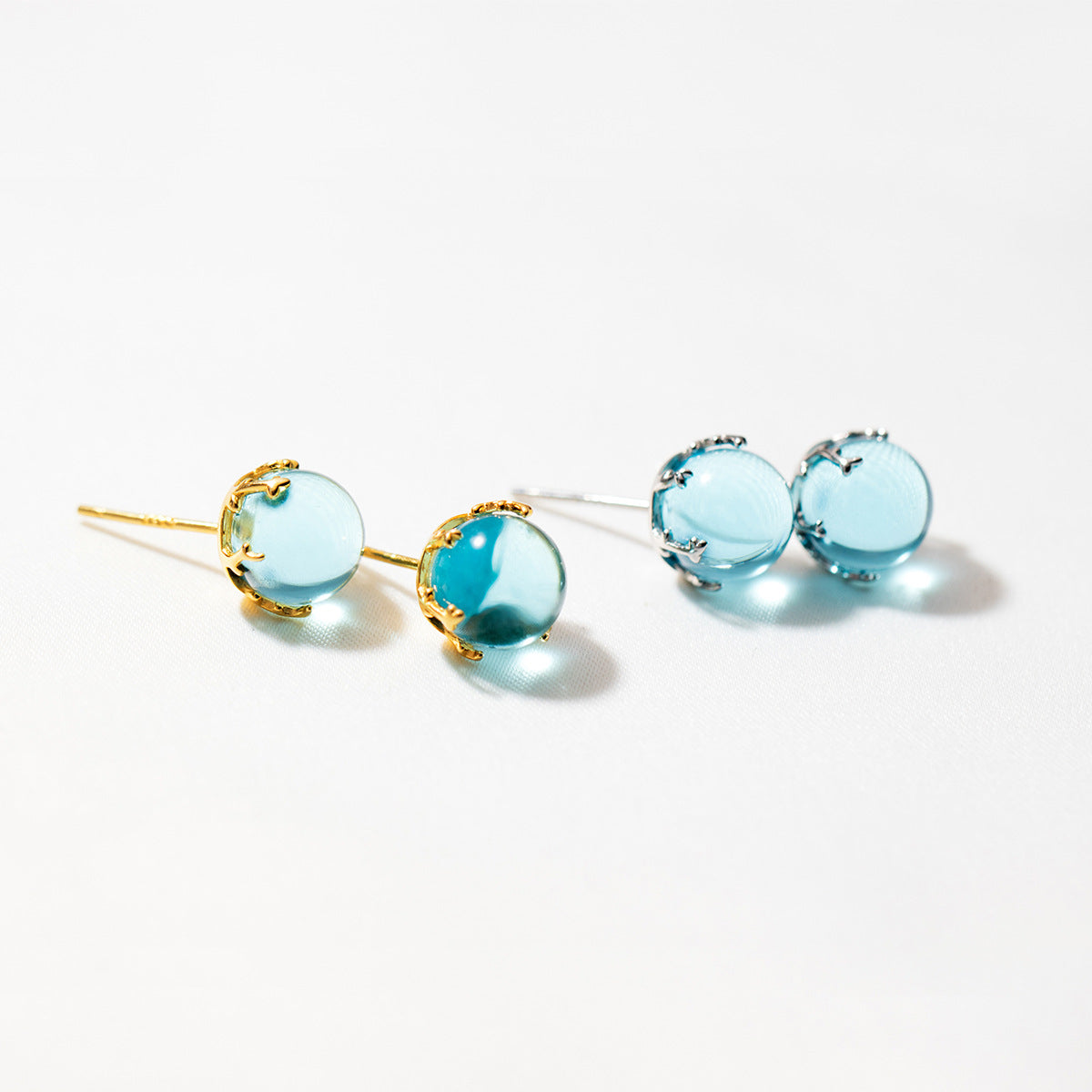 A set of 925 sterling silver mini blue crystal ball stud earrings, showcasing both the elegant gold and classic silver finishes.
